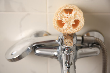 Natural loofah sponge on faucet in bathroom, closeupの写真素材