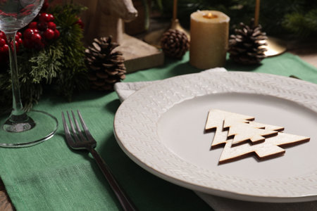 Festive place setting with beautiful dishware, cutlery and decor for Christmas dinner on wooden table, closeupの写真素材