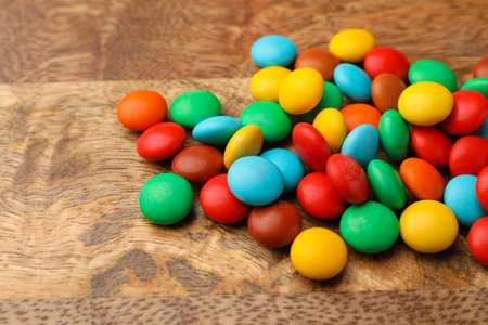 Tasty colorful candies on wooden table, closeup