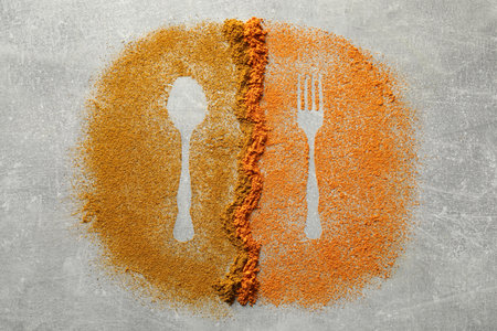 Silhouettes of cutlery made by spices on light gray table, flat layの写真素材