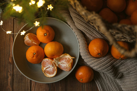 Fresh ripe tangerines and Christmas decor on wooden table, flat layの写真素材