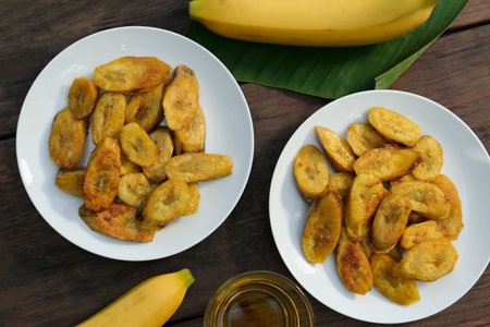 Flat lay composition with deep fried banana slices on wooden tableの写真素材