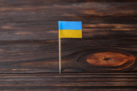 Small paper flag of Ukraine on wooden table, closeupの写真素材