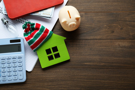 Flat lay composition with piggy bank and calculator on wooden table, space for text. Paying bills conceptの写真素材