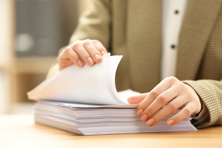 Woman working with documents at table in office, closeup