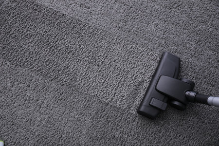 Modern vacuum cleaner on carpet, top view. Space for textの写真素材