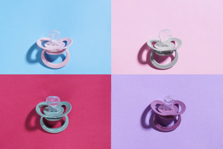 New baby pacifiers on color background, flat layの写真素材