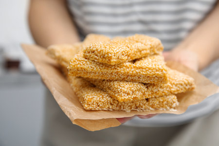 Woman holding delicious sesame kozinaki bars, closeupの写真素材