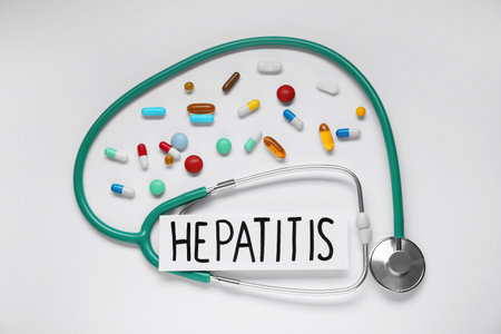 Word Hepatitis, stethoscope, and pills on white background, flat layの写真素材