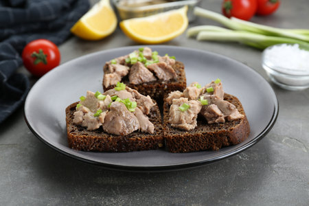 Tasty sandwiches with cod liver and green onion on light gray tableの写真素材