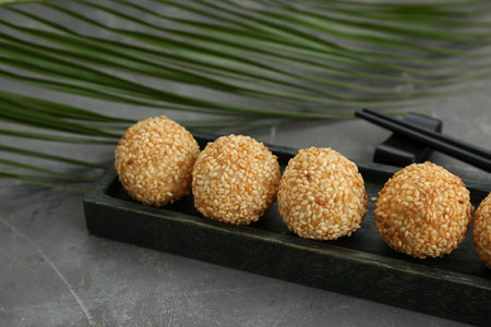 Delicious sesame balls and green leaf on gray table