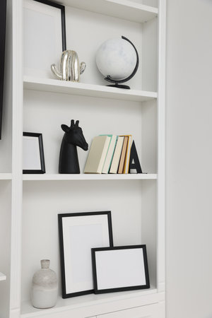 Books and different decorative elements on shelving unit indoorsの写真素材