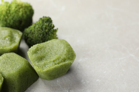 Frozen broccoli puree cubes with ingredient on marble table, closeup. Space for textの写真素材