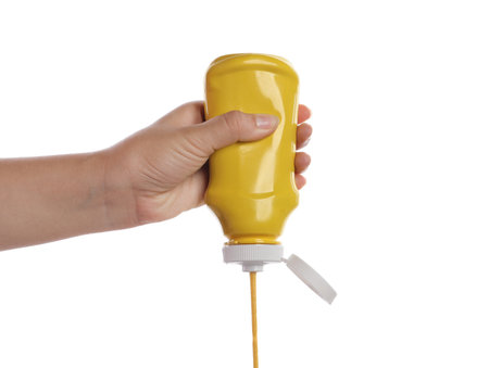 Woman with bottle of mustard on white background, closeupの写真素材