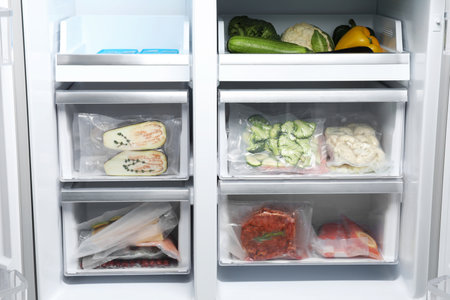 Vacuum bags with different products in fridge. food storageの写真素材