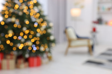 Blurred view of beautiful Christmas tree with festive lights in living roomの写真素材