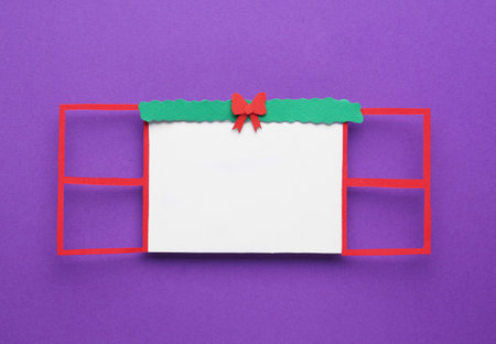 Open paper window frame with Christmas decoration on purple background. Space for textの写真素材