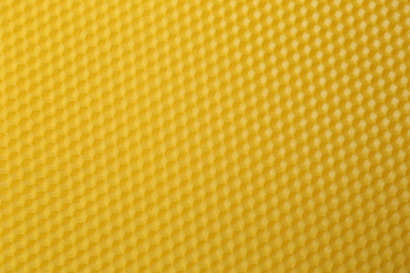 Natural beeswax sheet as background, top view