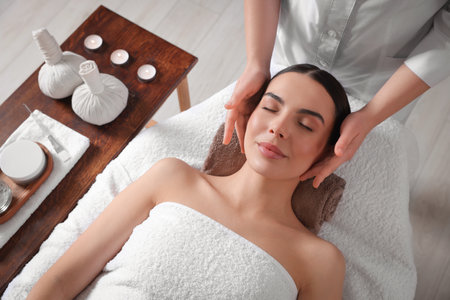 Young woman enjoying professional massage in spa salon, above viewの写真素材