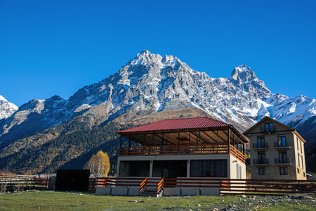 Picturesque view of village in high mountains under blue sky on sunny day