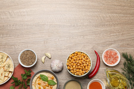Many different ingredients on wooden table, flat lay with space for text. Cooking delicious hummusの写真素材