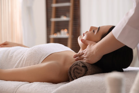 Young woman enjoying professional massage in spa salonの写真素材