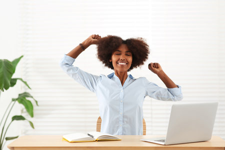 Smiling African American woman at wooden table indoorsの写真素材