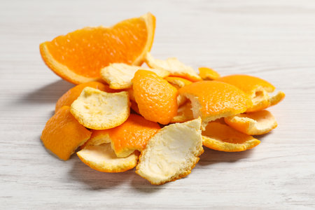 Orange peels preparing for drying and piece of fresh fruit on white wooden table, closeupの写真素材