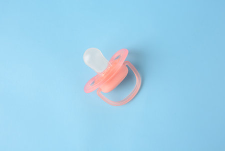 One new baby pacifier on light blue background, top viewの写真素材
