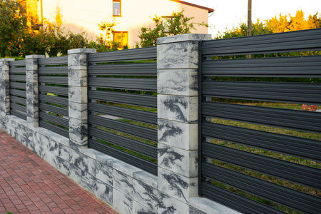 Beautiful stone fence with iron railing near pathway outdoors