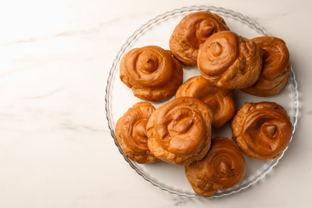 Delicious profiteroles on white marble table, top view. Space for text
