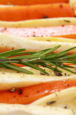 Slices of parsnip and carrot with rosemary, closeupの写真素材