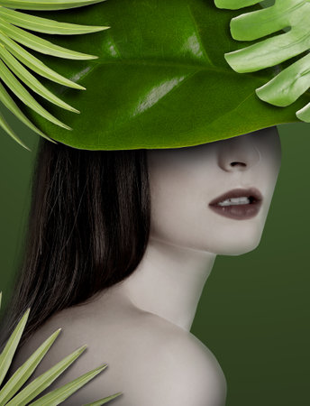 Woman with green tropical leaves on dark olive color background. Stylish collage designの写真素材