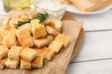 Delicious crispy croutons with rosemary on white wooden table, closeupの写真素材
