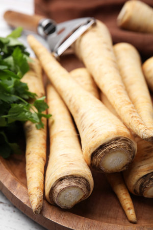 Raw parsley roots and fresh herb on wooden board, closeupの写真素材
