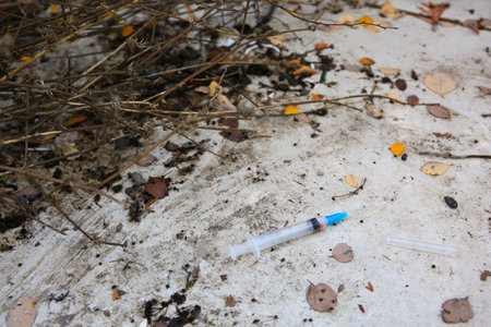 Disposable syringe with needle on concrete surface outdoorsの写真素材