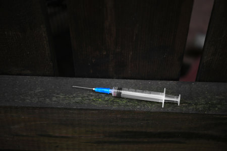 Empty syringe on surface of wooden fence outdoorsの写真素材