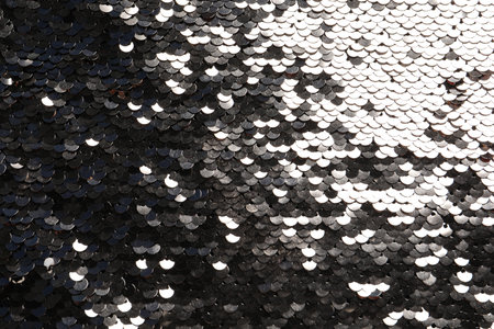 Texture of beautiful golden sequins as background, top view