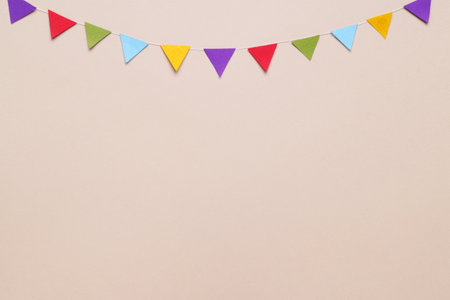 Colorful bunting flags on beige background, flat lay. Space for textの写真素材