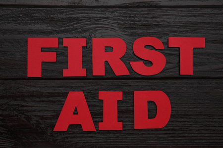 Words First Aid made of red letters on black wooden table, flat layの写真素材