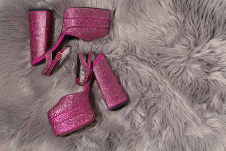 New pink high heeled shoes with platform and square toes on gray fur, flat lay. Space for text