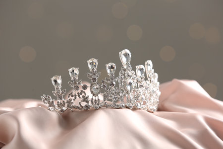 Beautiful silver tiara with diamonds on light clothの写真素材