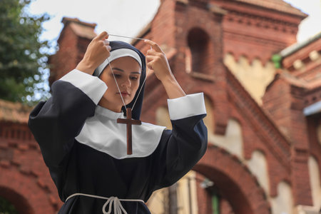Young nun wearing Christian cross near building outdoorsの写真素材