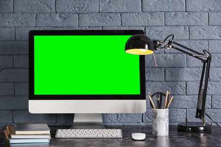 Computer display with chroma key on desk in room. Comfortable workplaceの写真素材