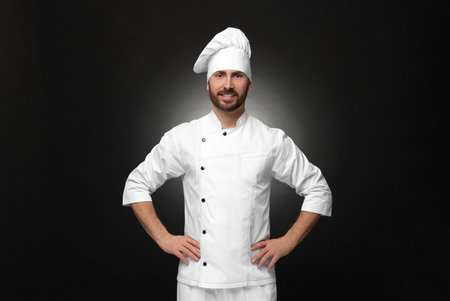 Smiling mature male chef on black backgroundの写真素材
