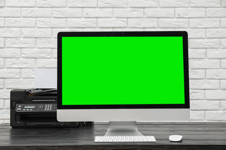 Computer display with chroma key on desk in room. Comfortable workplaceの写真素材