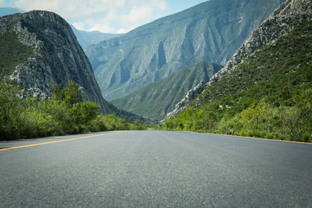 Picturesque view of big mountains and bushes near roadの写真素材