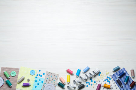 Different sewing items on white wooden background, flat lay. Space for textの写真素材