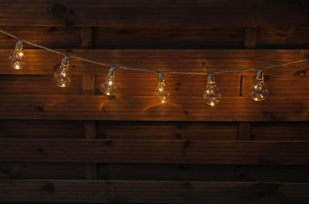 Garland of lamps hanging on wooden wall. string lights