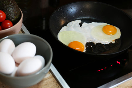 Frying eggs in the kitchen for tasty breakfast